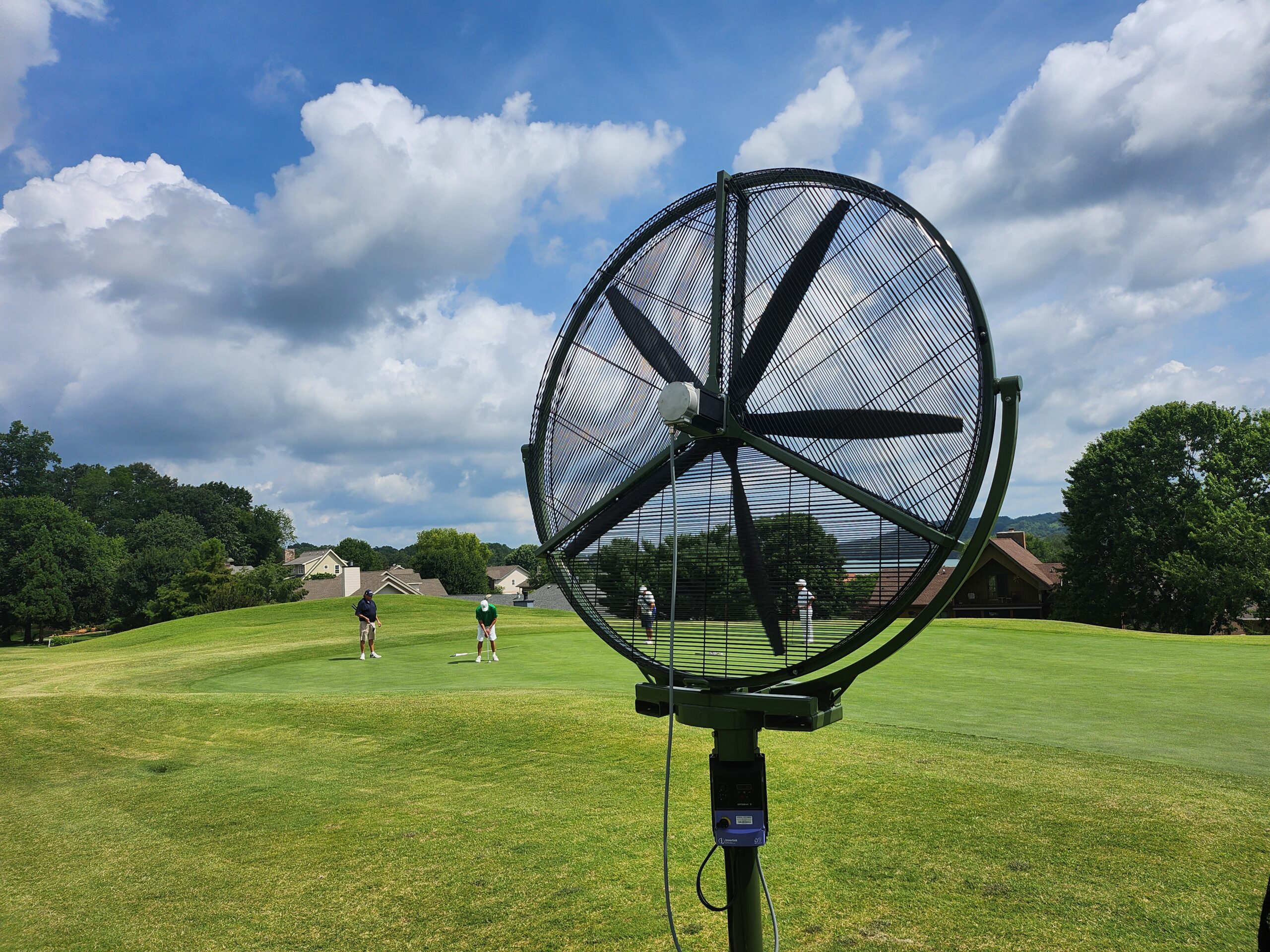 Performance Fan operating quietly near golfers, enhancing turf management with minimal noise